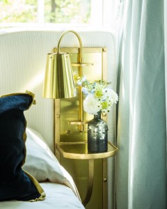 A gold built-in sconce and table makes this custom headboard, designed by Ashley Gilbreath, a one of kind piece.           