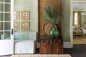 Designed by Ashley Gilbreath, the welcoming foyer features shiplap walls and a mix of contemporary and antique pieces.          