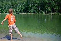 A neighborhood boy skips rocks at Spoonwood Lake.                   