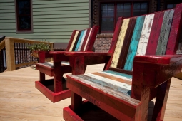 A wide back porch deck offers plenty of space for these colorful lounge chairs.              
