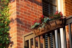A flower box accents the back porch railing of this custom home.             