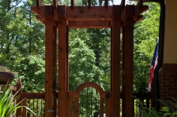This backyard garden features a stone path, daffodils, and a wooden pergola.              