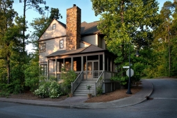 Nestled within nature, this custom home features a spacious screened-in porch and brickwork chimney.             