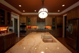 A gorgeous white marble island offers residents additional preparation space in this custom kitchen.                               