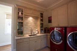 The wooden cabinetry in this laundry room provides plenty of storage space.                               
