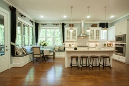 This open kitchen flows into the breakfast area highlighted by banquette seating surrounded by windows overlooking the trees.               