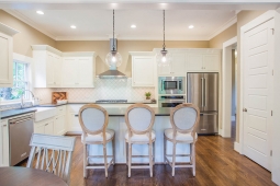 The light and airy kitchen in the Redbud Cottage features a large island, farmhouse sink, and Kitchenaid appliances.   