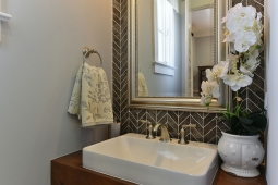 Herringbone tile and wood vanity creates a beautiful contemporary design in this hall bathroom.                   