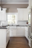 White cabinets, clean modern tile, farmhouse sink, and honed granite makes this kitchen a showstopper!        